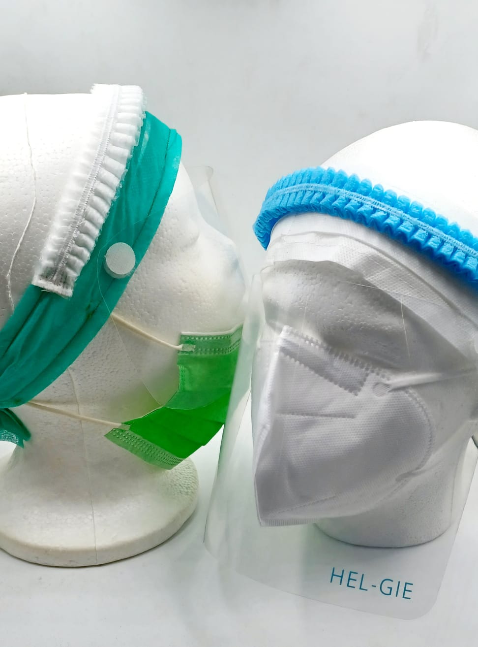 The HG Mask on display heads — an integrated face mask with removable face shield and headgear